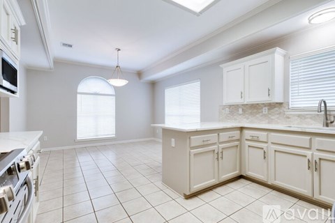 A kitchen with white cabinets and appliances.