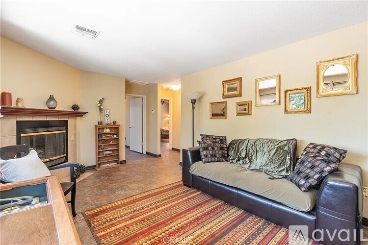 A living room with a couch, a fireplace, and a rug.