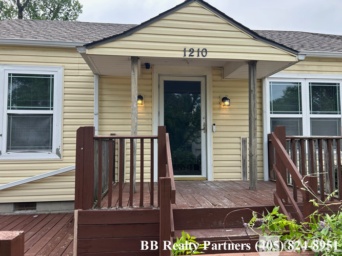 A yellow house with the number 1210 on the front.