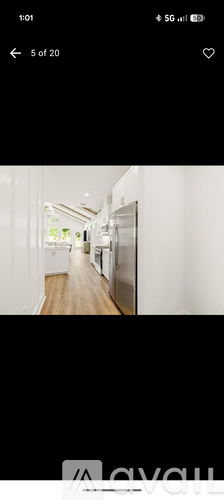 A long, narrow hallway with white walls and wooden floors.