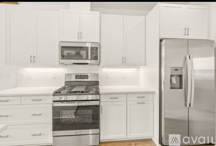 A kitchen with white cabinets and stainless steel appliances.