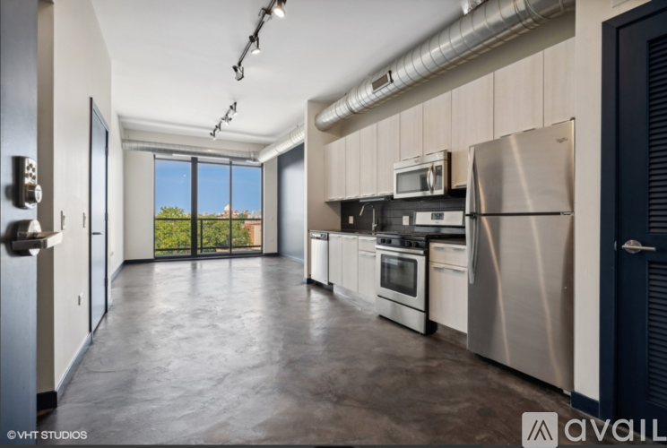 A kitchen with stainless steel appliances and a view of the outdoors through a sliding glass door.