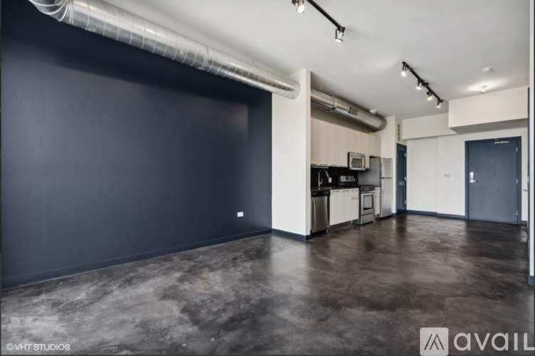 A spacious room with a dark floor and a large grey wall.