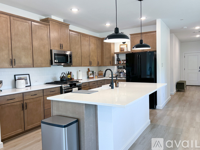A kitchen with wooden cabinets and a white island.