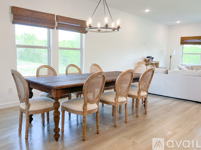 A dining room with a large table and chairs.