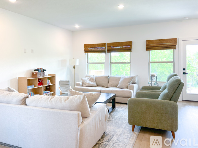 A living room with a white couch, a green armchair, and a coffee table.