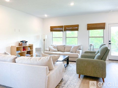 A living room with a white couch, a green armchair, and a coffee table.