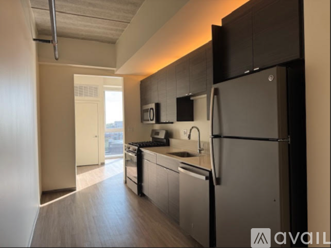 A modern kitchen with a refrigerator, sink, and stove.