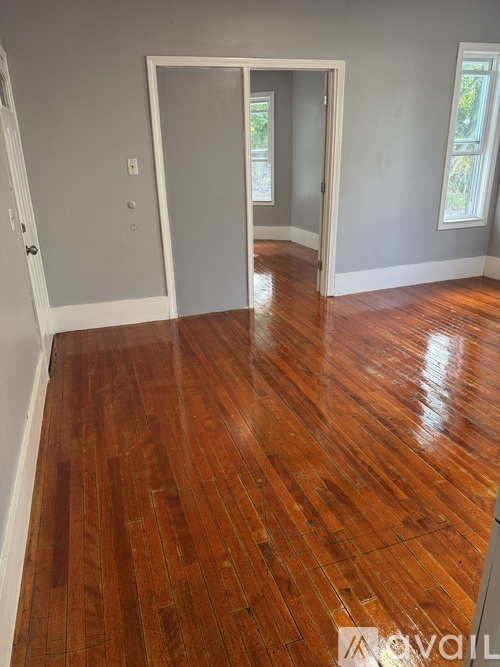 A room with wood flooring and two doors.