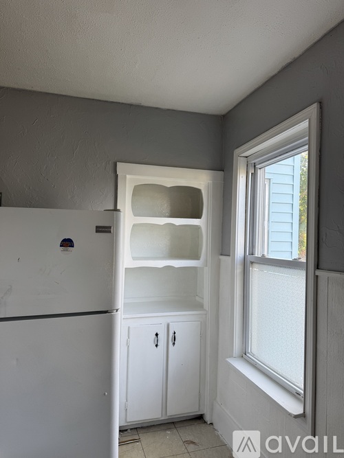 A kitchen with a white fridge and a window.