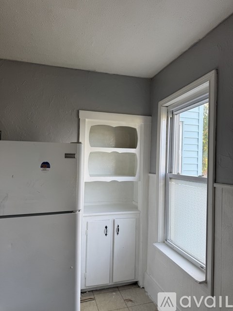 A kitchen with a white fridge and a window.
