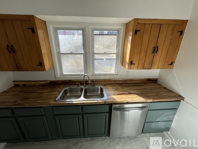 A kitchen with a wooden countertop and a window above the sink.