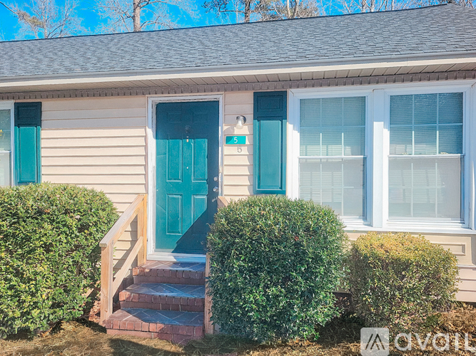 A house with a blue door and windows with white frames.