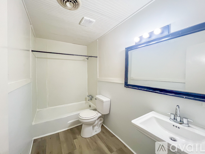A white toilet sits next to a sink in a small bathroom.