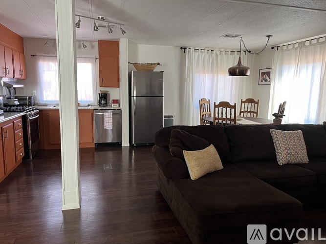 A kitchen with orange cabinets and a refrigerator.