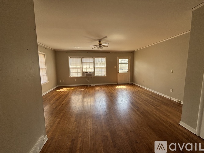 A room with wooden floors and a ceiling fan.