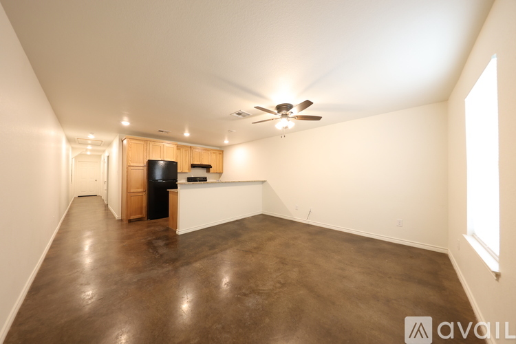 A spacious room with a ceiling fan and a window on the right side.