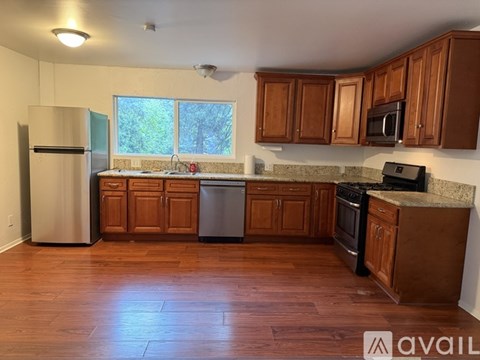 A kitchen with wooden cabinets and a refrigerator.