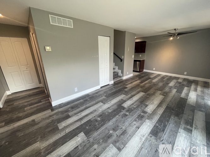 A room with wooden flooring and a ceiling fan.
