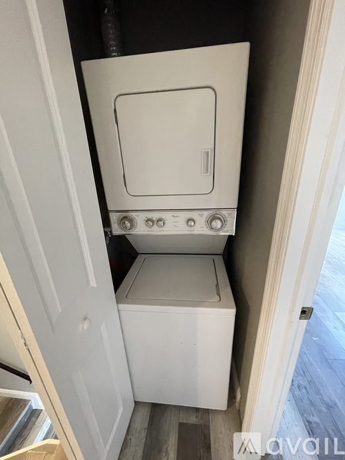 A white toilet with a closed lid is installed in a small space.