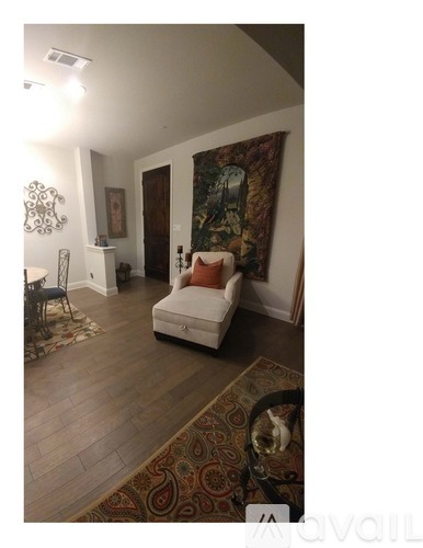 A living room with a couch, chair, and rug.