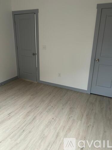 A room with two doors and a wooden floor.