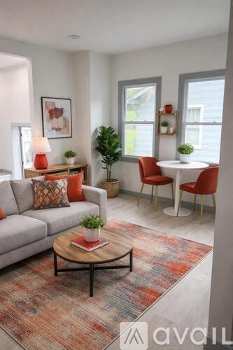 A living room with a grey couch, a coffee table, and a rug.