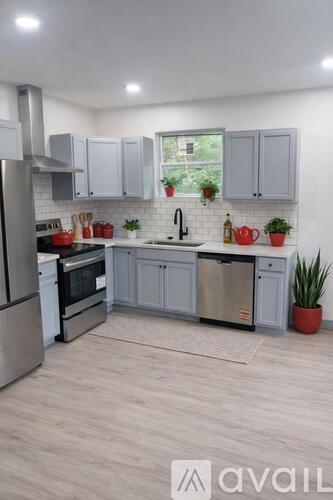 A kitchen with a refrigerator, oven, and sink.