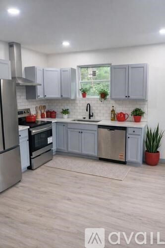 A kitchen with a refrigerator, oven, and sink.