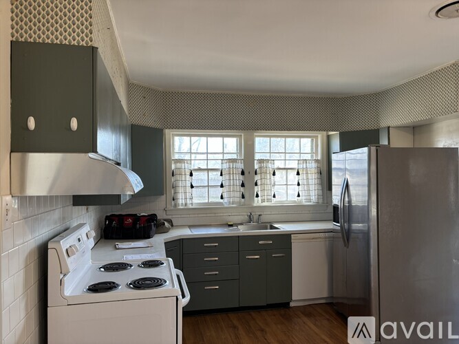 A kitchen with a white stove top oven and a white refrigerator.
