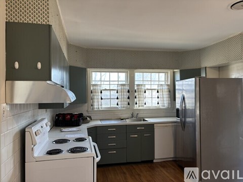 A kitchen with a white stove top oven and a white refrigerator.