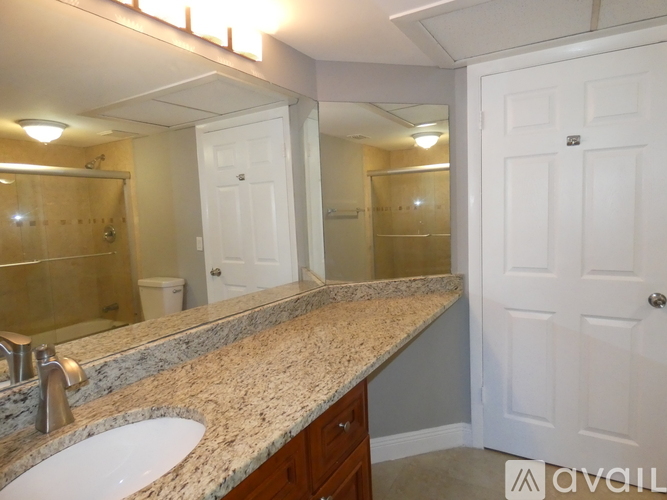 A bathroom with a sink, mirror, and a white door.