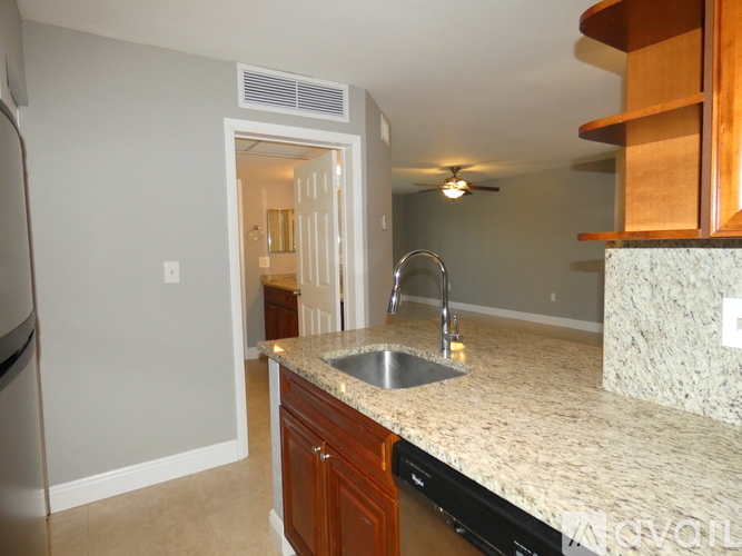 A kitchen with a sink and a refrigerator.