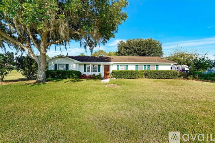 A house with a green lawn and a tree in front of it.