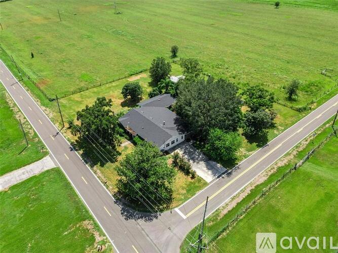 A house surrounded by green grass and trees.
