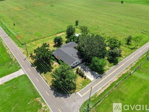 A house surrounded by green grass and trees.