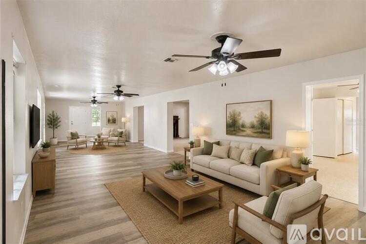 A spacious living room with a ceiling fan and a couch.
