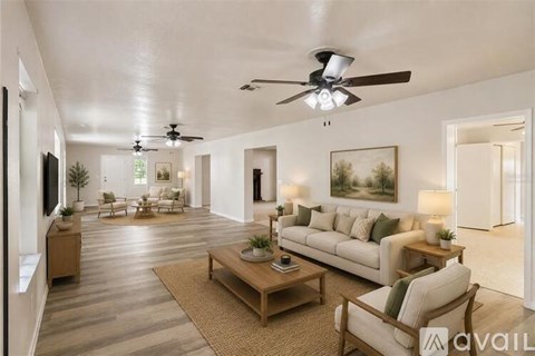 A spacious living room with a ceiling fan and a couch.
