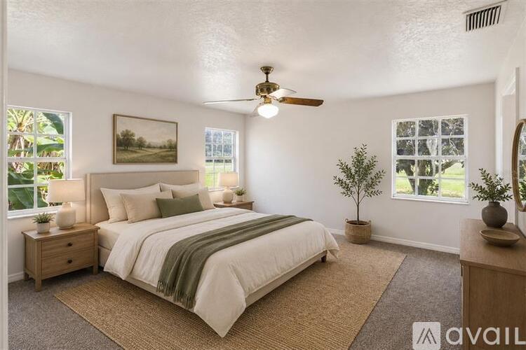 A bedroom with a bed, nightstand, and a ceiling fan.