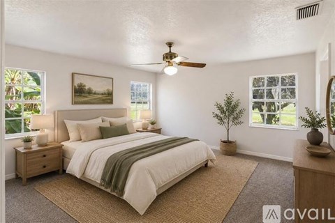 A bedroom with a bed, nightstand, and a ceiling fan.