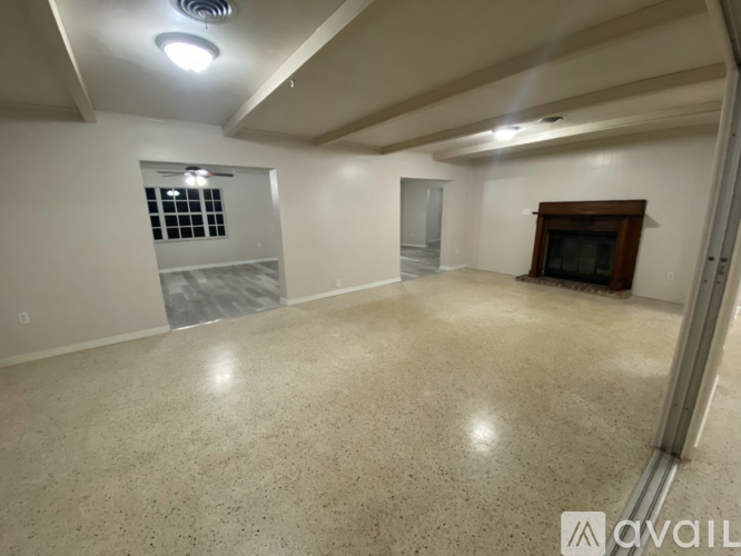 A spacious room with a fireplace and a large window.