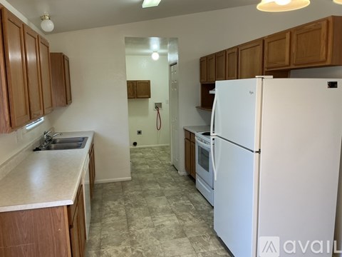 A kitchen with a white refrigerator and wooden cabinets.