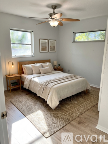 A bedroom with a bed, a ceiling fan, and a rug.