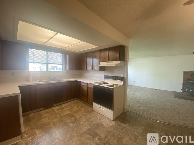A kitchen with brown cabinets and a tiled floor.