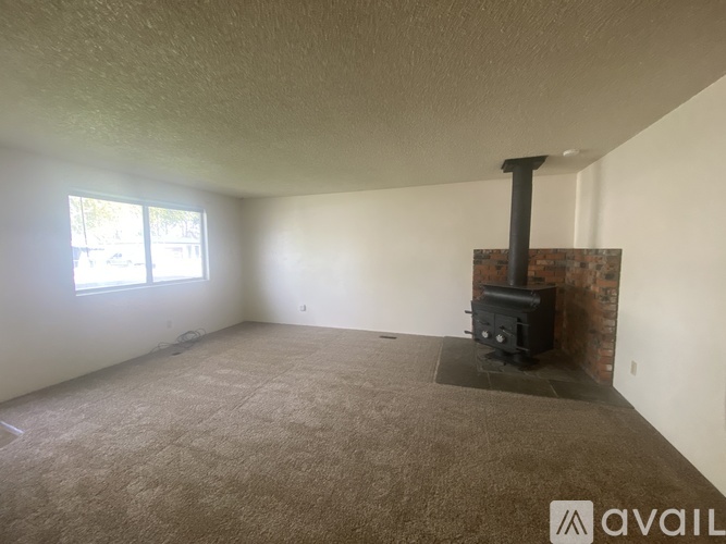 A room with a fireplace and carpeted floor.