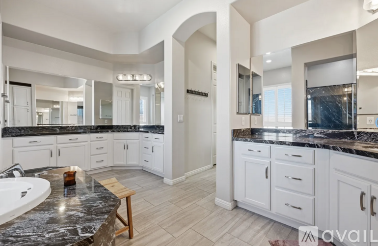 A modern kitchen with white cabinets and a marble countertop.