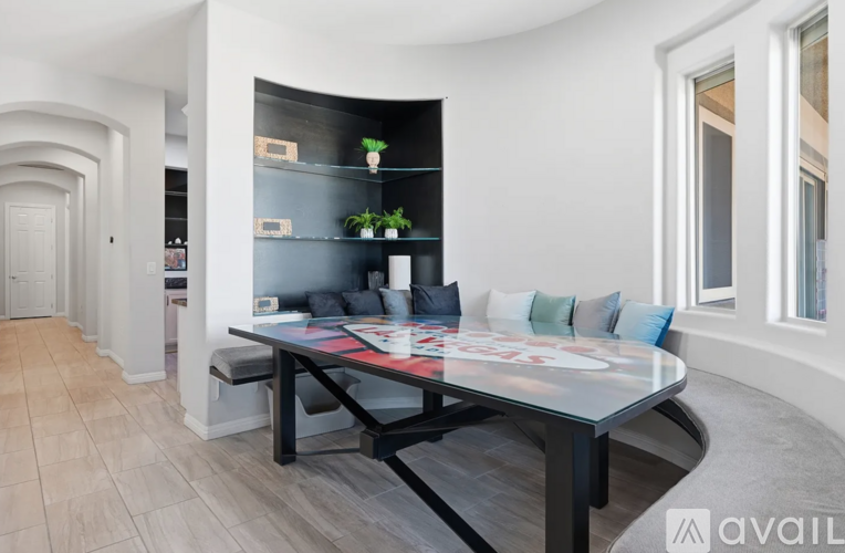 A modern dining room with a glass table and bench seating.
