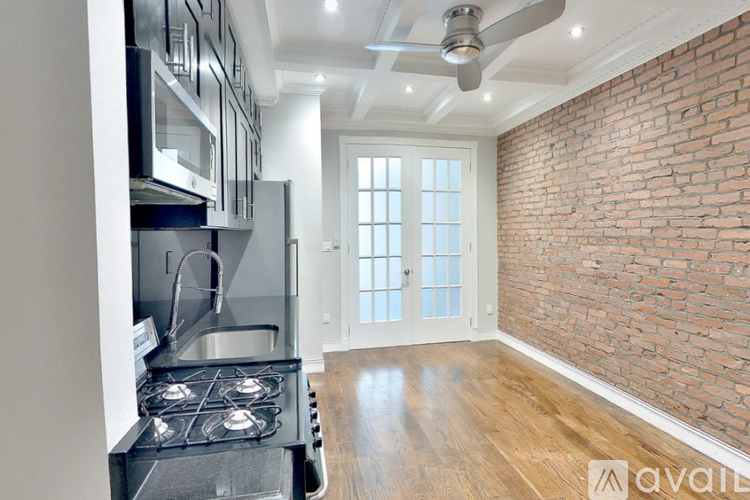 A kitchen with a stove top oven and a brick wall.