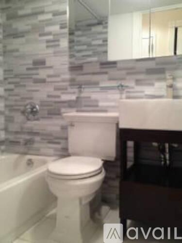 A white toilet in a bathroom with a stone wall.
