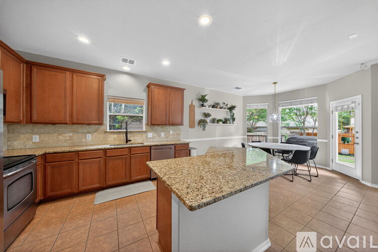A kitchen with brown cabinets and a granite countertop.